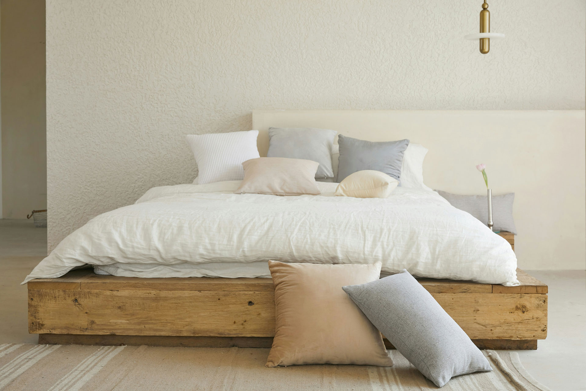 Din guide til de bedste senge. Moderne soveværelse med en stilfuld seng, der har en hovedgavl, luksuriøst sengetøj og puder, der skaber en elegant og komfortabel atmosfære.